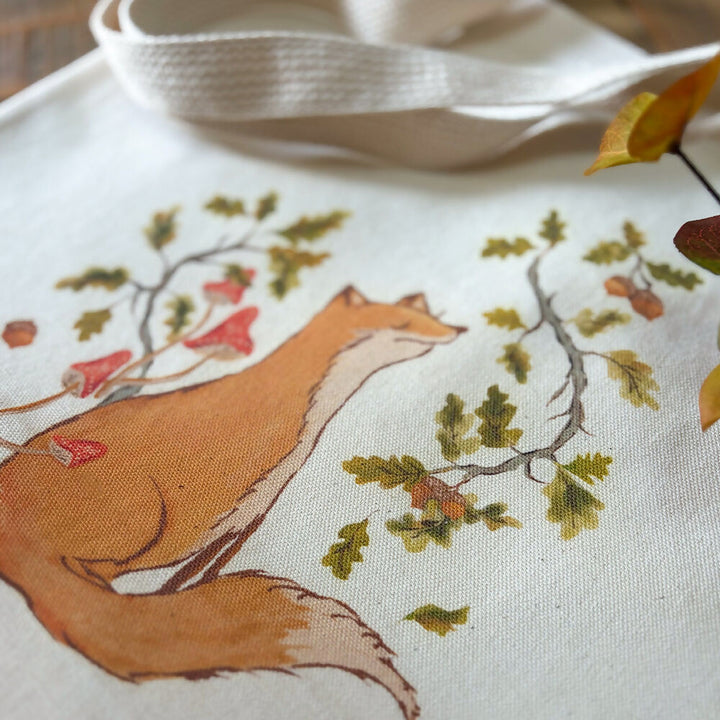 Artist illustration of fox sitting among autumn leaves, branches and acorns