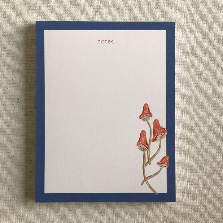 hand painted red cap mushrooms with a dark blue border desk notepad