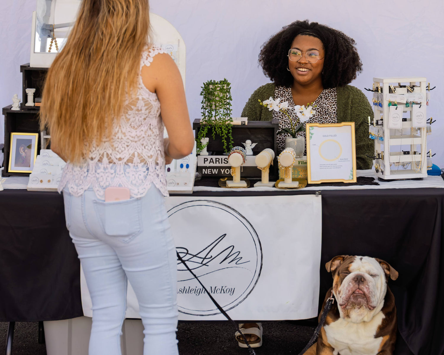 Woman with a dog interacting with a vendor at an event