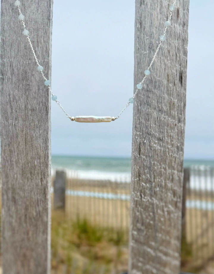 Truro Necklace SS Suspended from beach fence on a cloudy day